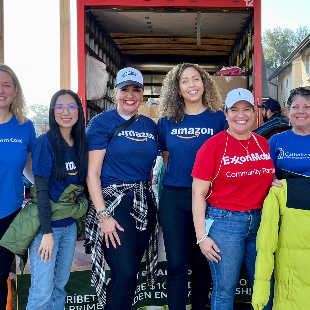 Volunteers standing together at a community coat drive donation event.